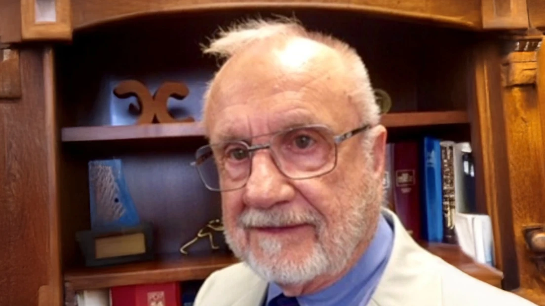 Feature photo of dentist Dr. Robert Anderton standing in front of office bookshelves.