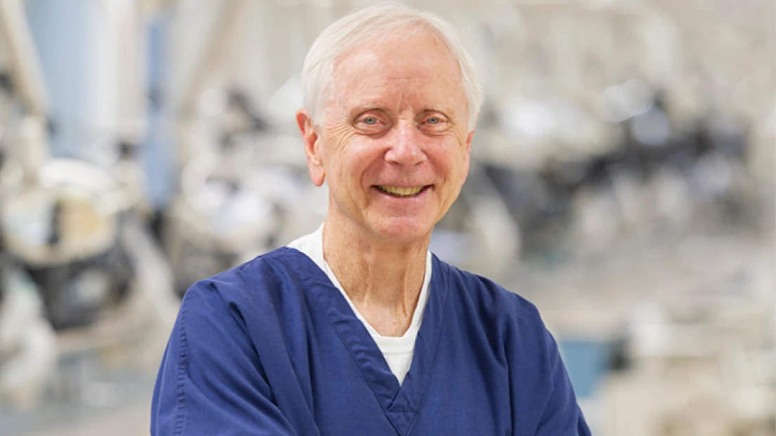 Dentist Dr. Amp Miller dressed in medical scrubs standing in a simulation laboratory.