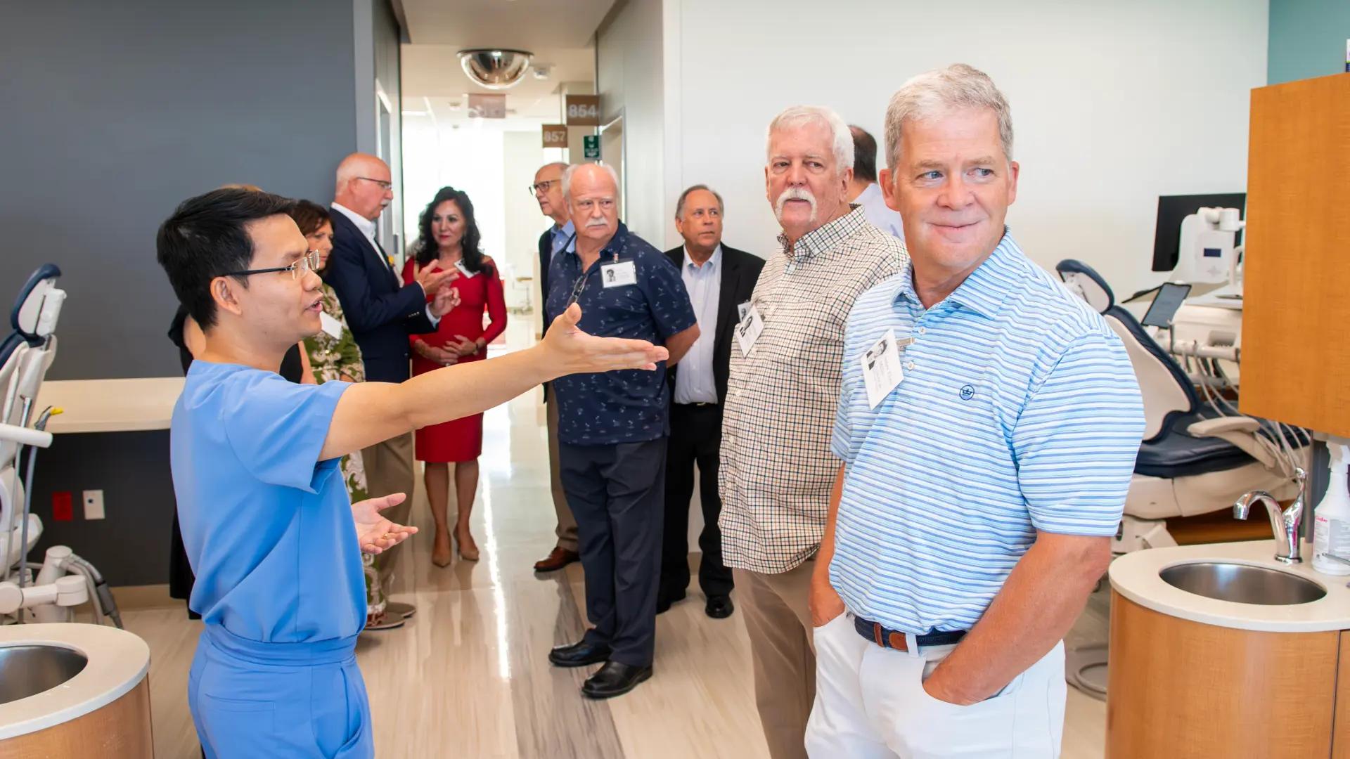 Group of alumni listening to a dental student speak at a dental school class reunion.
