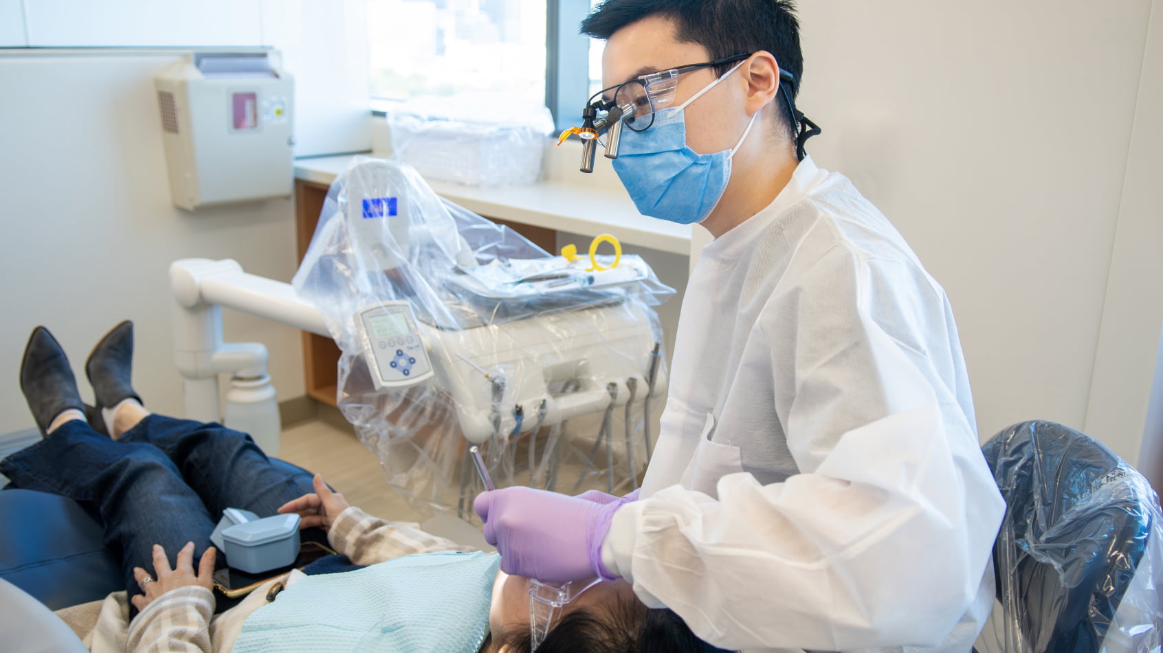 A dental student treats a patient in a dental clinic.