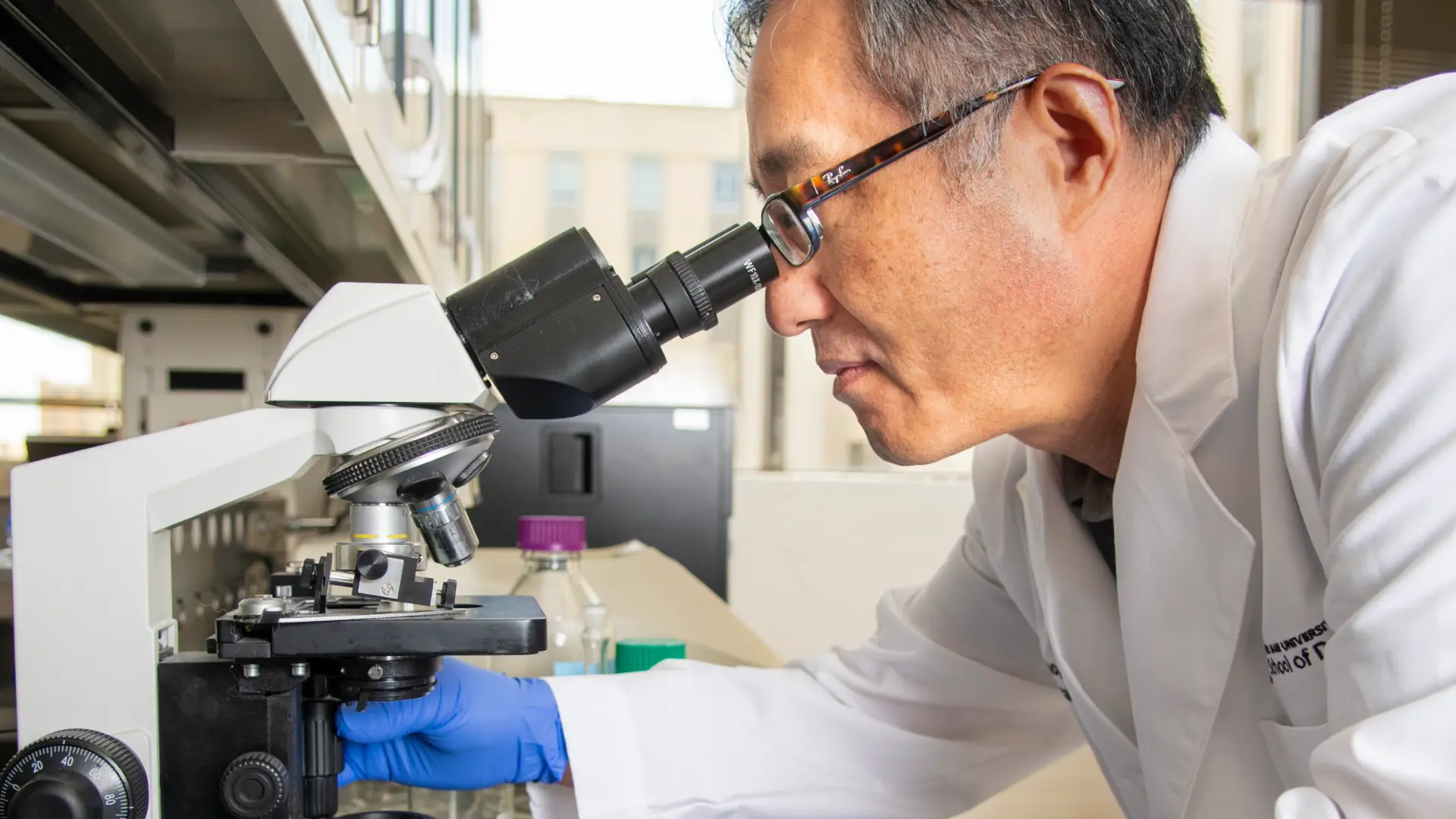 Dental researcher at a microscope.