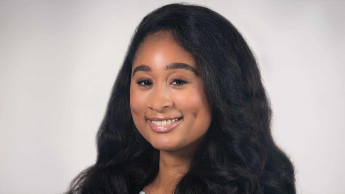 Profile headshot of Jada Pierre smiling against a light gray background