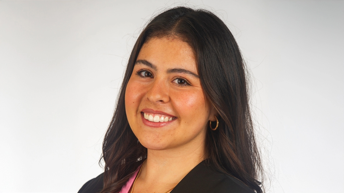 Profile headshot of Laura Anzola smiling against a gray background.