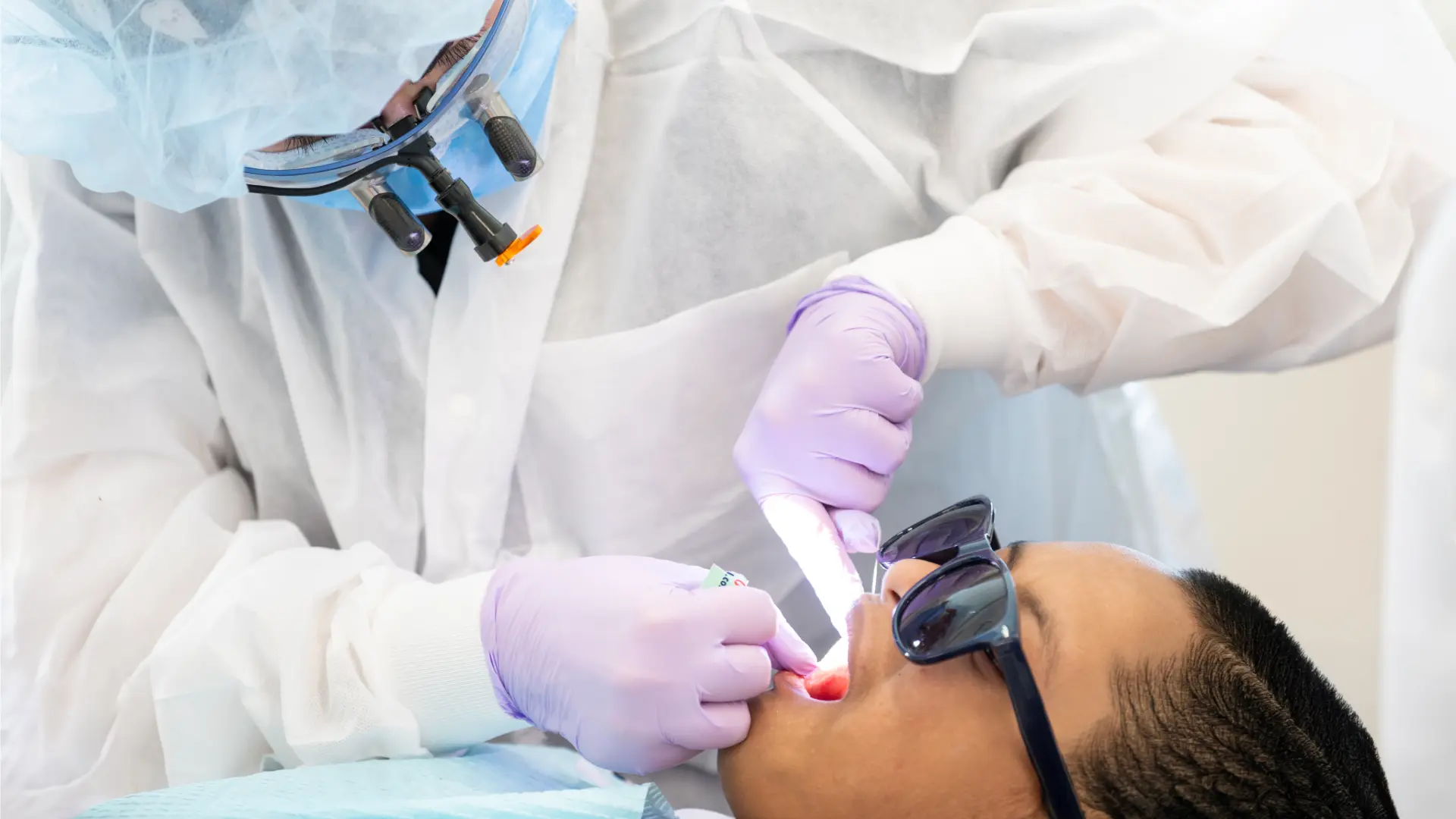Student pediatric dentist flossing a child's teeth.