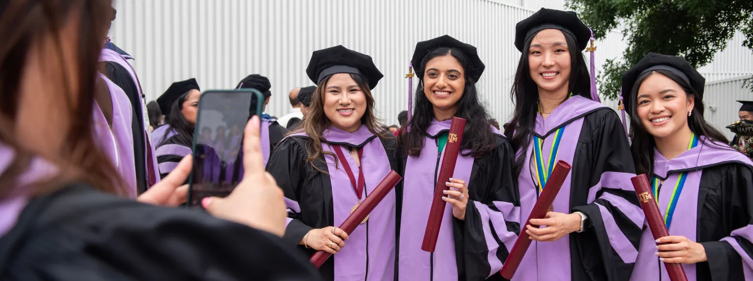 Photo of students after graduation in cap and gown taking pictures